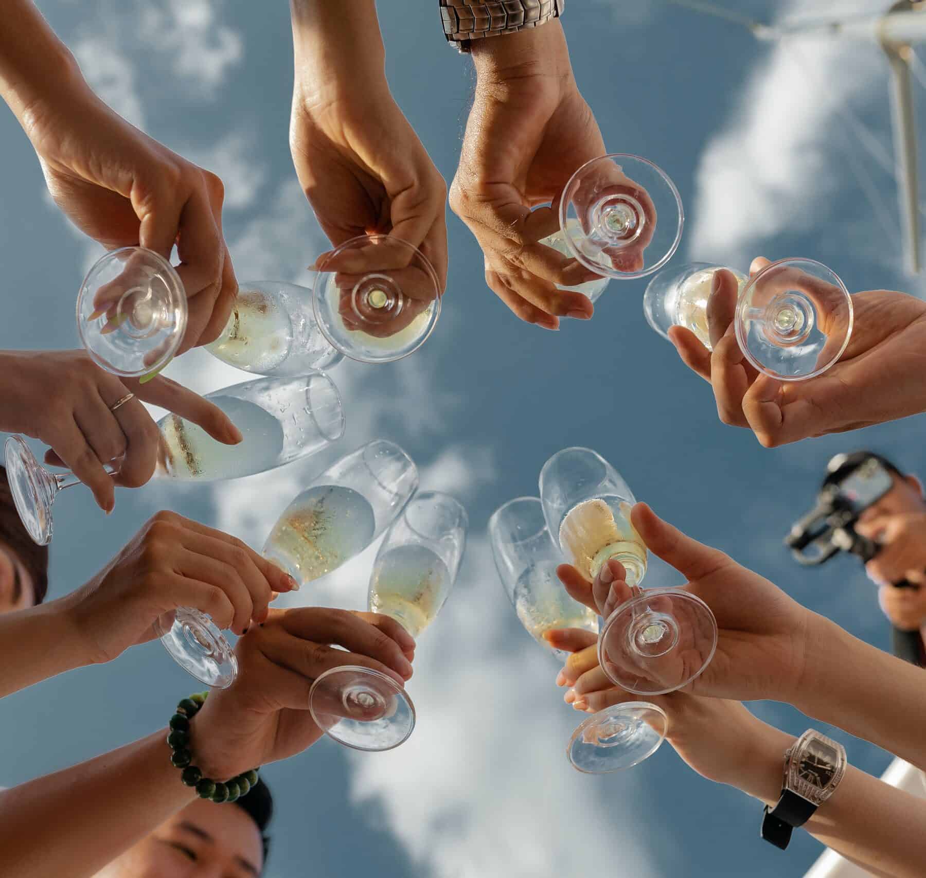 picture from a downwards angle looking up at the sky. A circle of women holding glasses of champagne in their hands