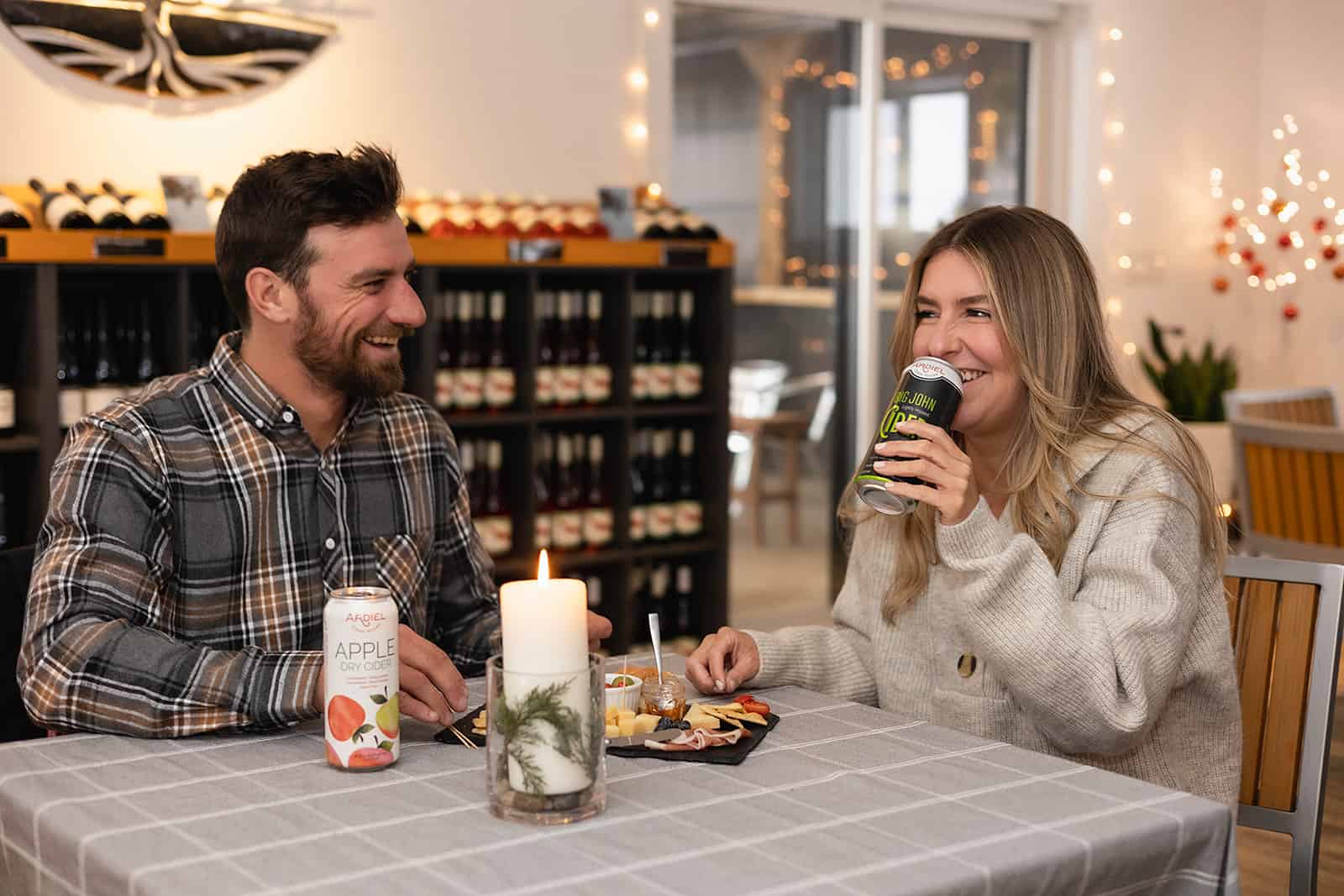 A man and a woman enjoying Ardiel Cider at a set table inside